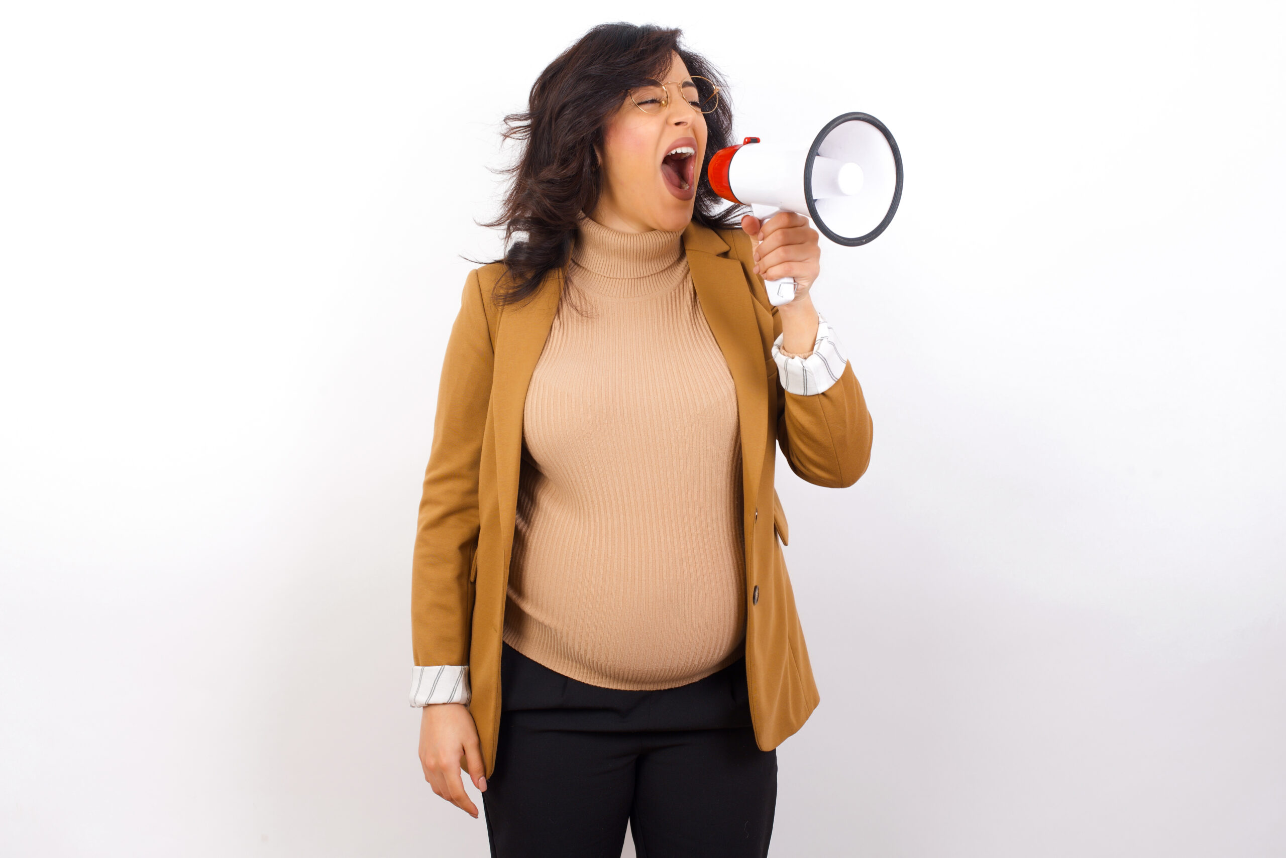 Pregnant person holds a megaphone and speaks loudly into it.