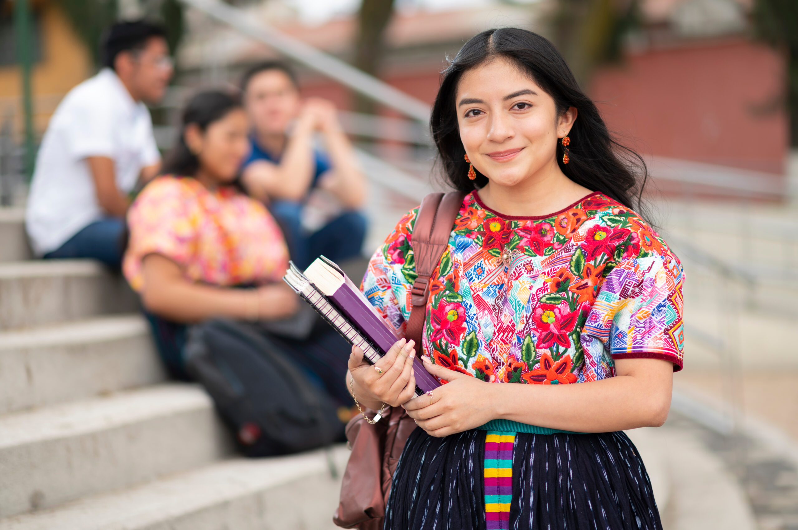 Portrait Of A femme Indigenous Latin American College Student With Books In Hands and slight smile